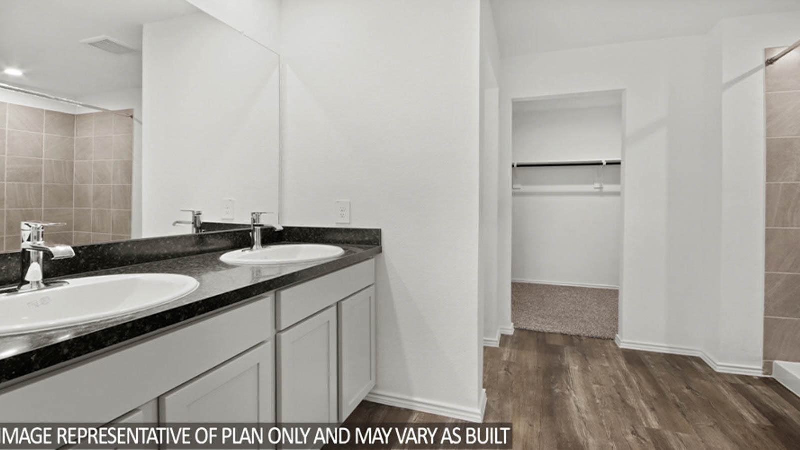 Primary bathroom with a double sink, a separate toilet room, and a spacious walk-in closet.