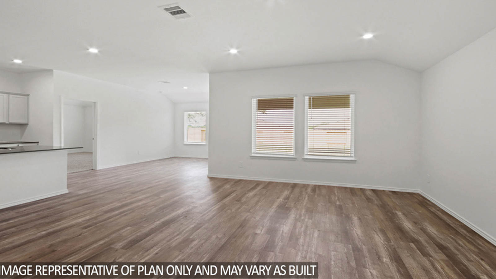 Open concept living and dining area with vinyl flooring and bright windows.