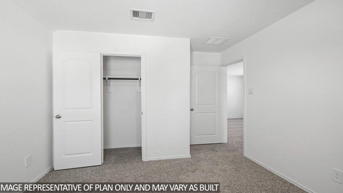 Secondary bedroom with carpet flooring.
