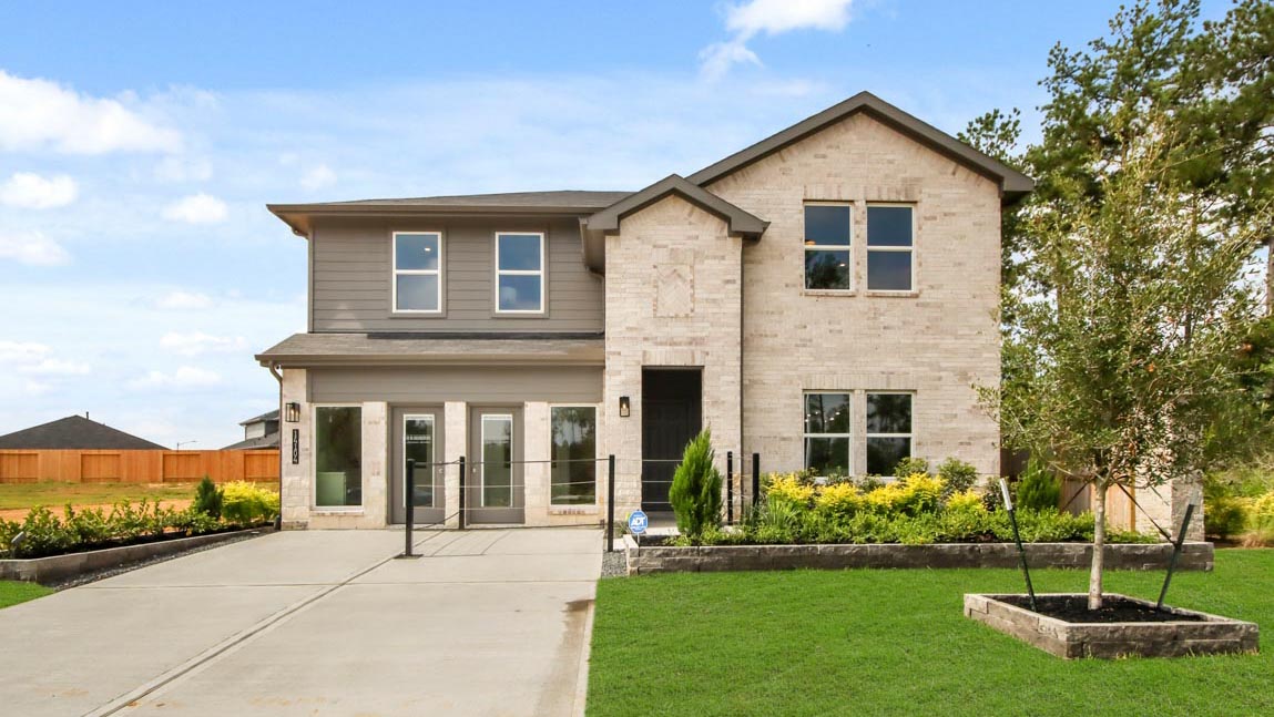 Two-story home with tan details and a two-car garage.