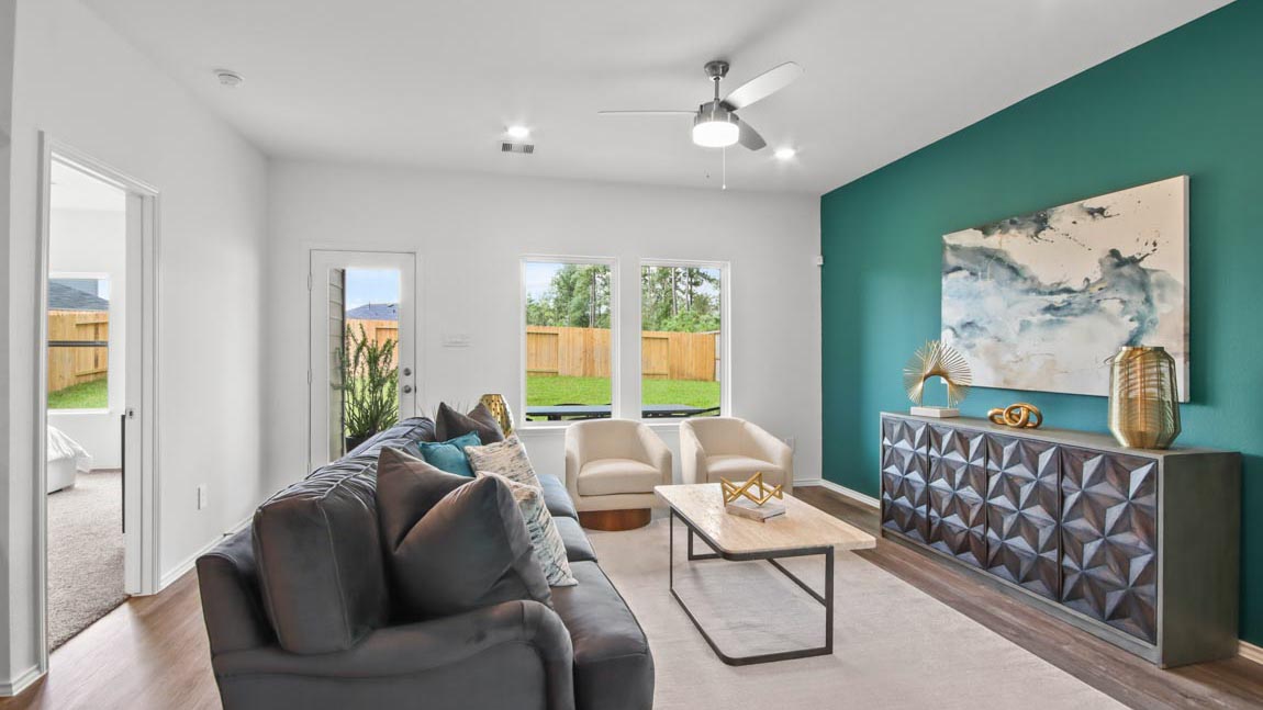 Living room with vinyl flooring and bright windows.