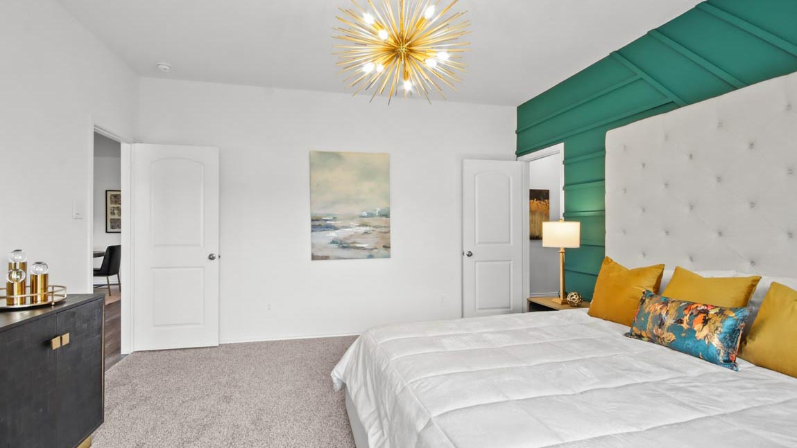 Primary bedroom with carpet flooring and bright windows.