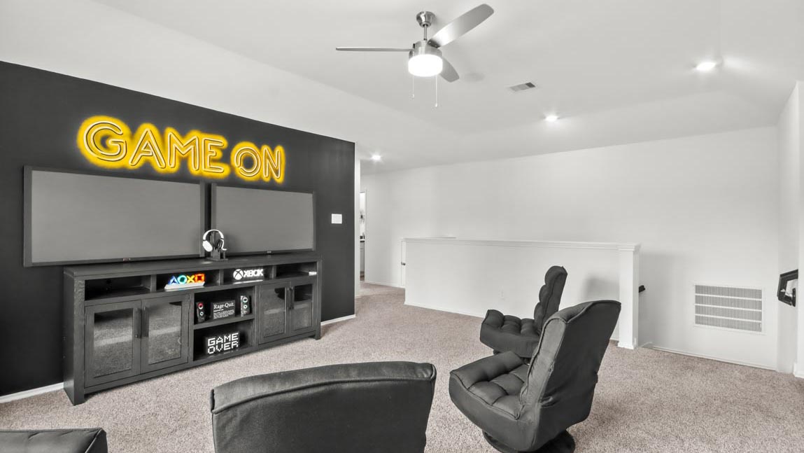 Upstairs game room with carpet flooring.