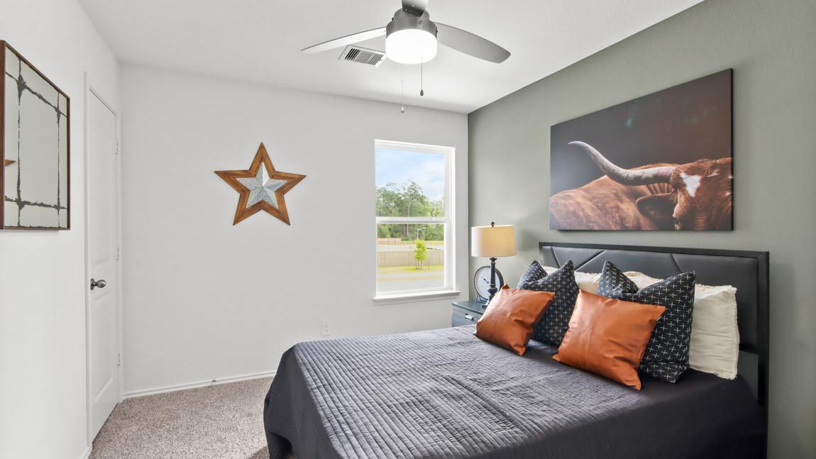 Secondary bedroom with carpet flooring and a bright window.