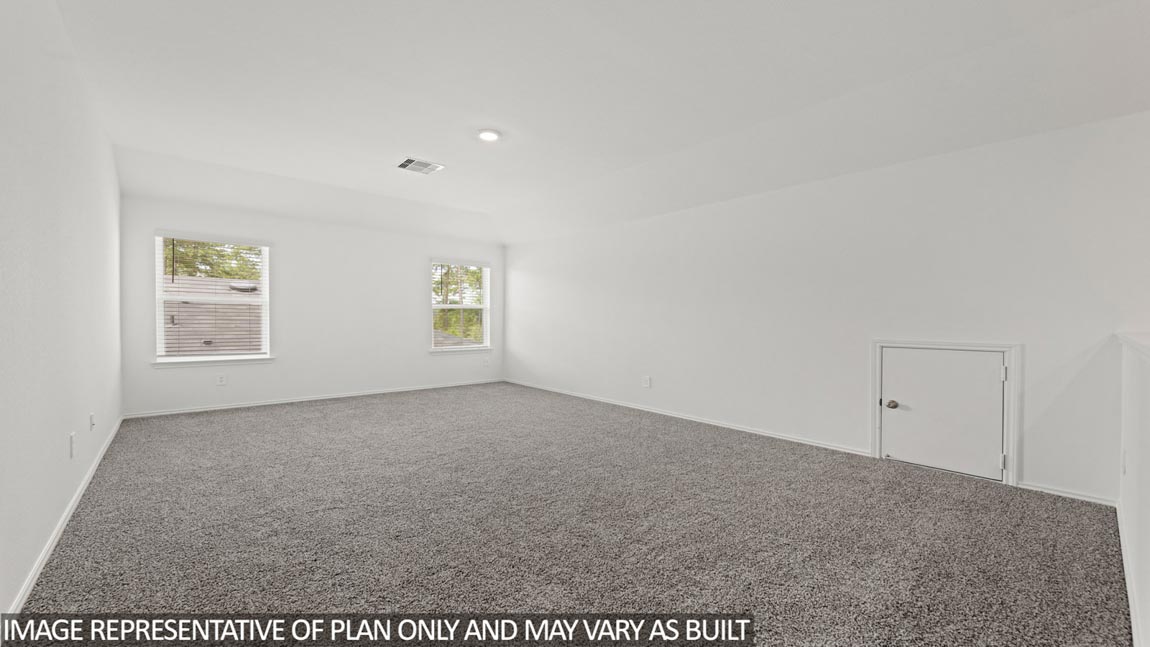 Upstairs game room with carpet flooring and bright windows.