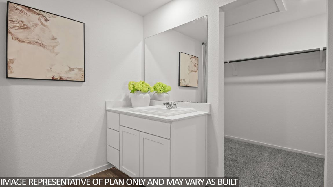 Primary bathroom with a double sink and a spacious walk-in closet.