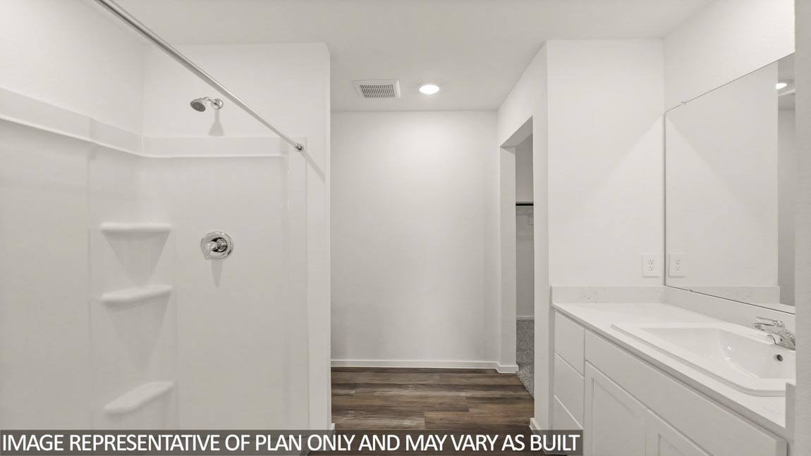 Primary bathroom with a standing shower, a double sink, and a separate toilet room.