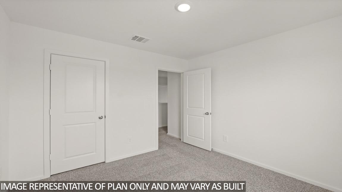 Secondary bedroom with carpet flooring