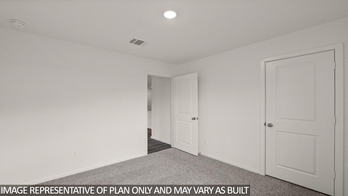 Secondary bedroom with carpet flooring