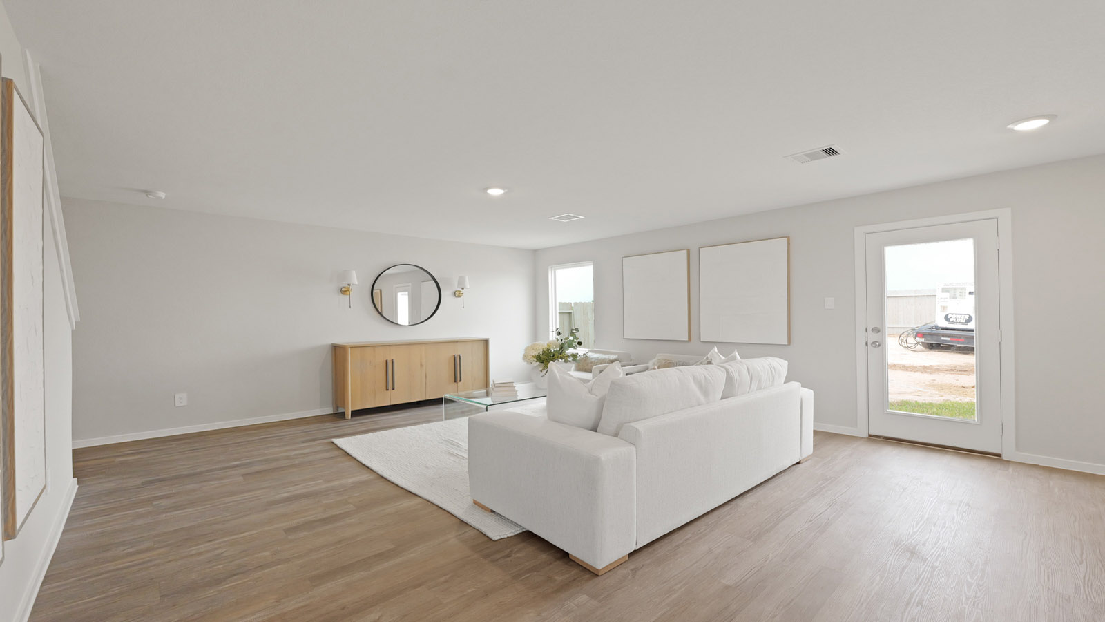 Open concept living and dining area with vinyl flooring and bright windows.