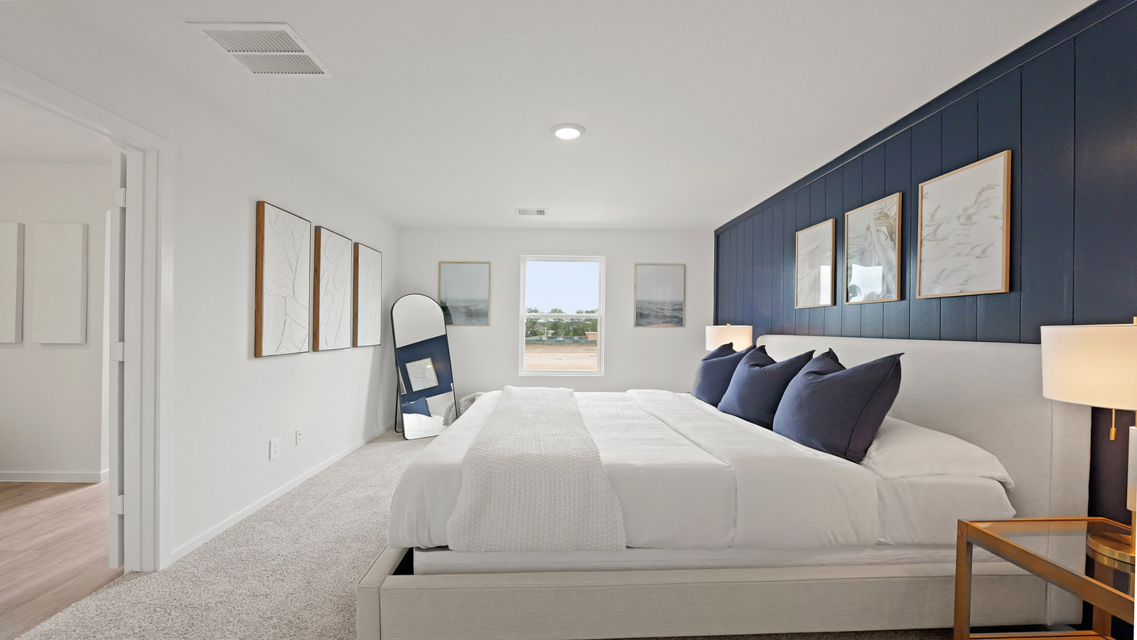 Primary bedroom with carpet flooring and bright windows.