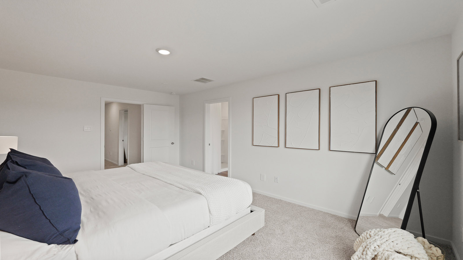 Primary bedroom with carpet flooring and bright windows.