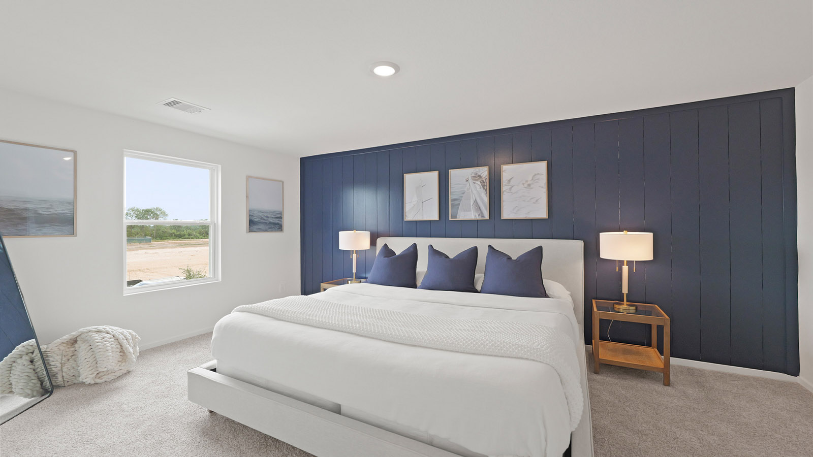 Primary bedroom with carpet flooring and bright windows.