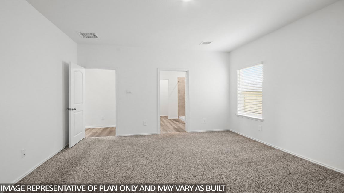Primary bedroom with carpet flooring and bright windows.