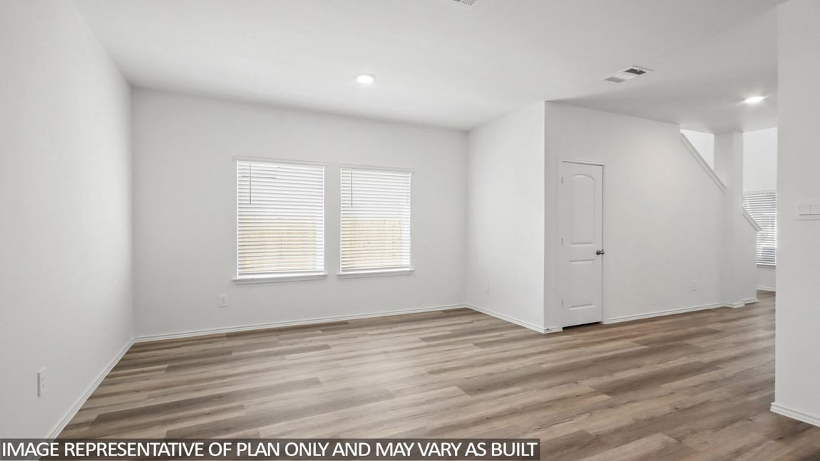 Dining area with vinyl flooring and bright windows.