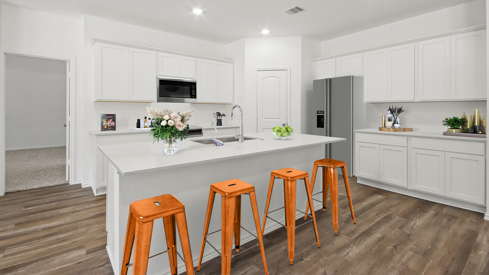 Staged kitchen with stainless-steel appliances and a tall pantry.