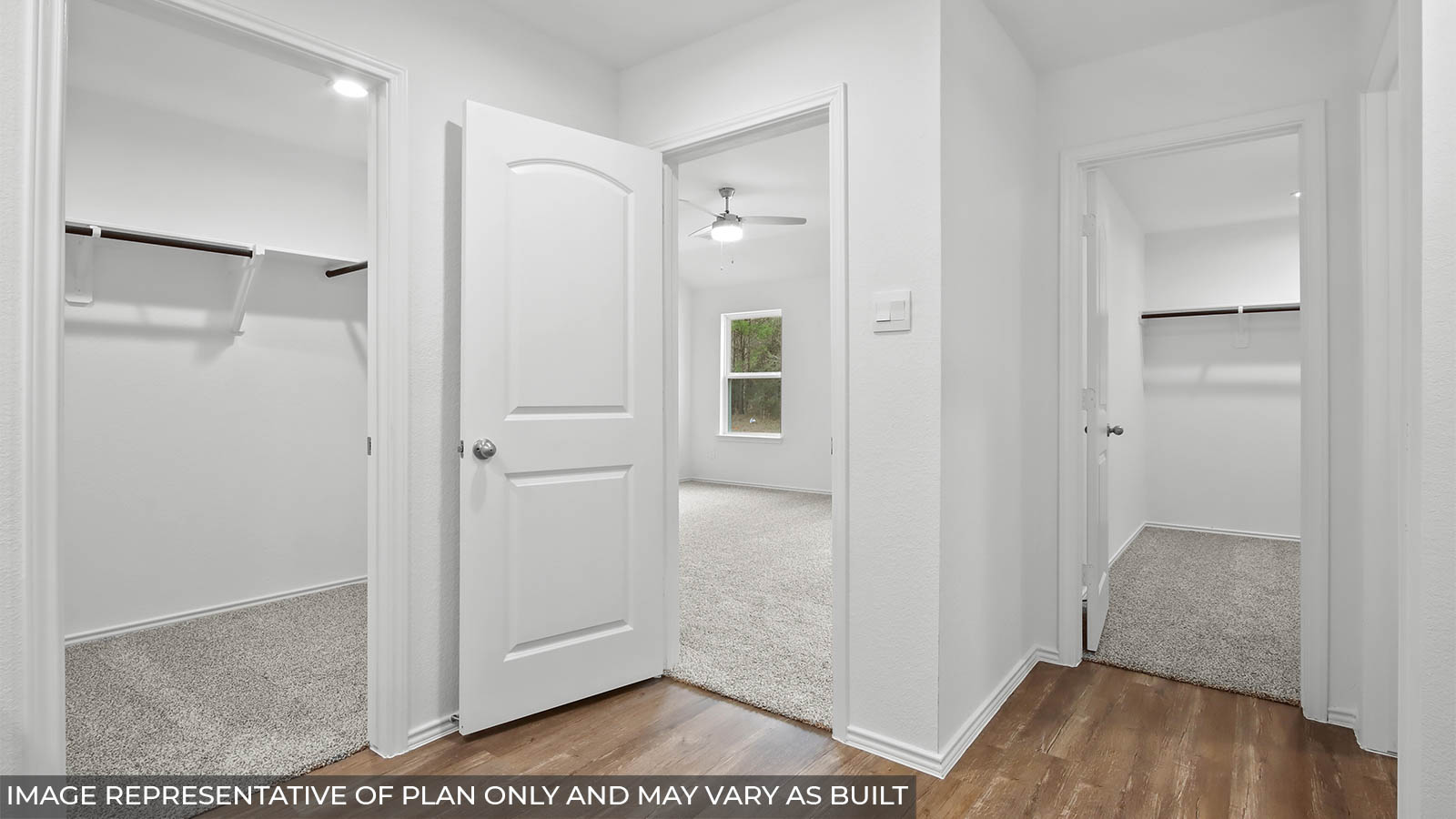 Primary bathroom with a separate toilet room and a spacious walk-in closet with carpet flooring and overhead stroage space.