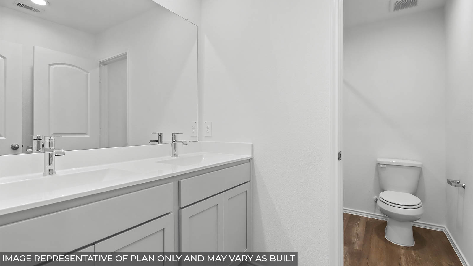 Secondary bathroom with a double sink and a separate toilet room.