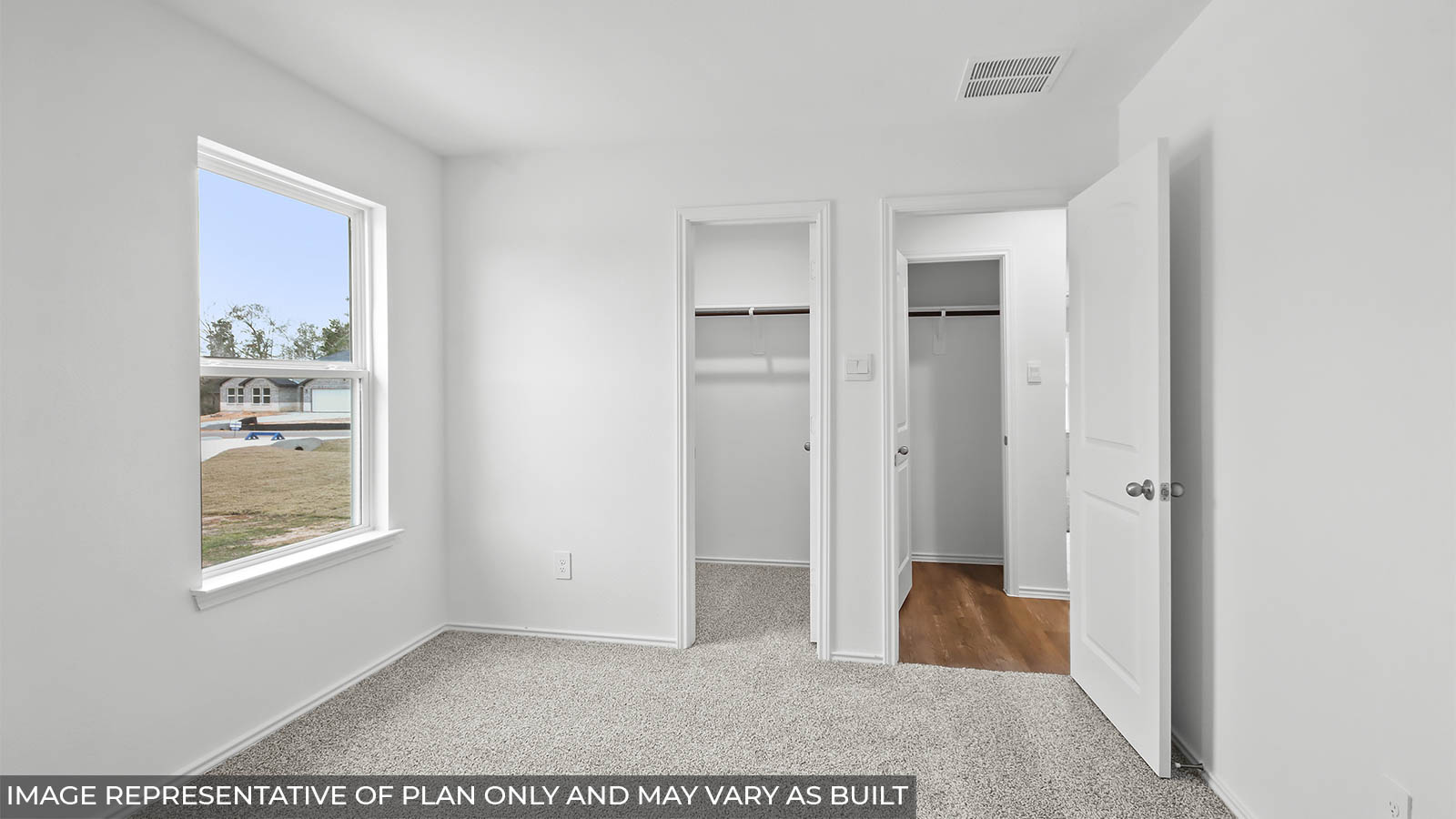 Secondary bedroom with carpet flooring and a bright window.