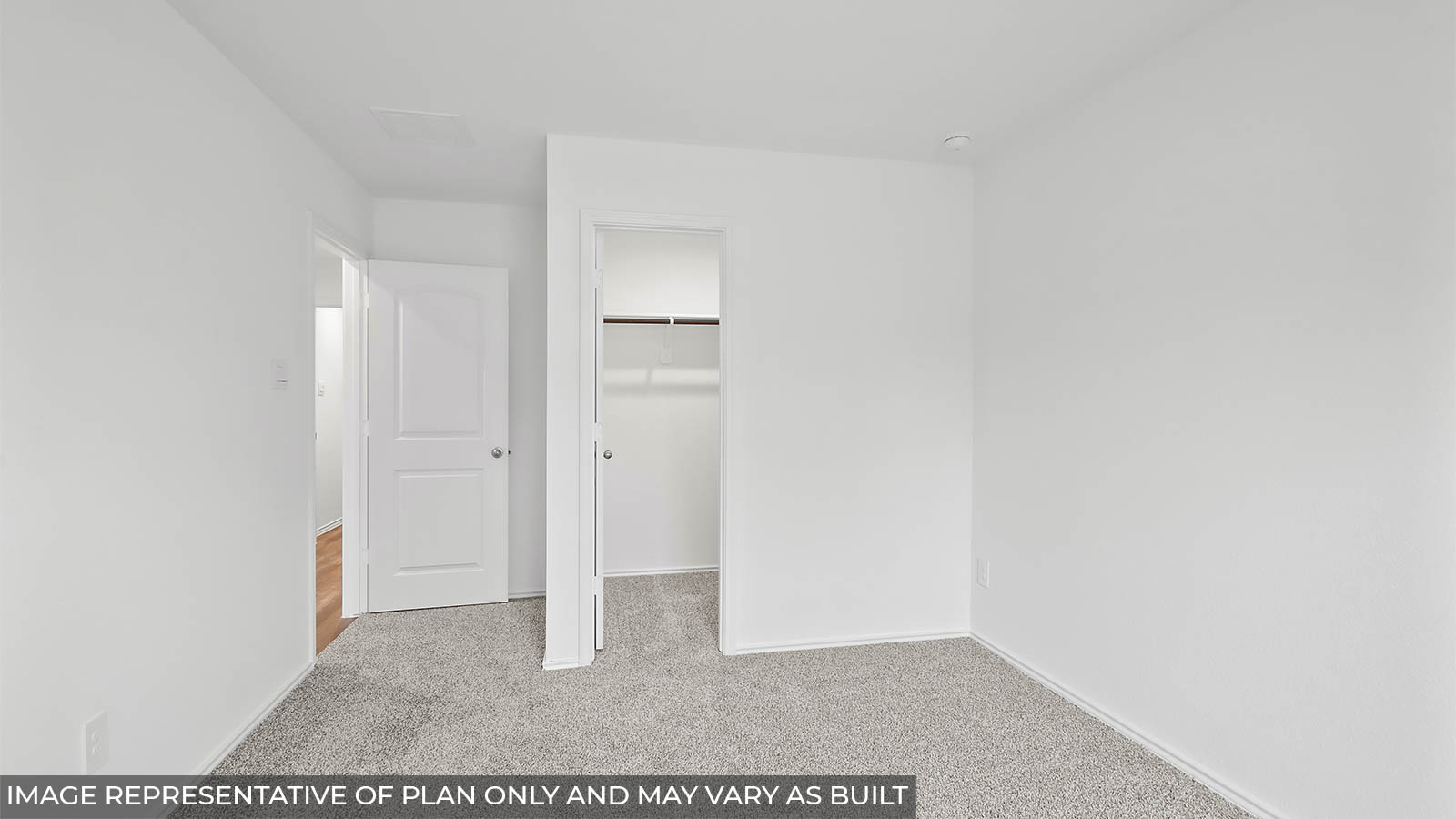 Secondary bedroom with a tall closet and carpet flooring.