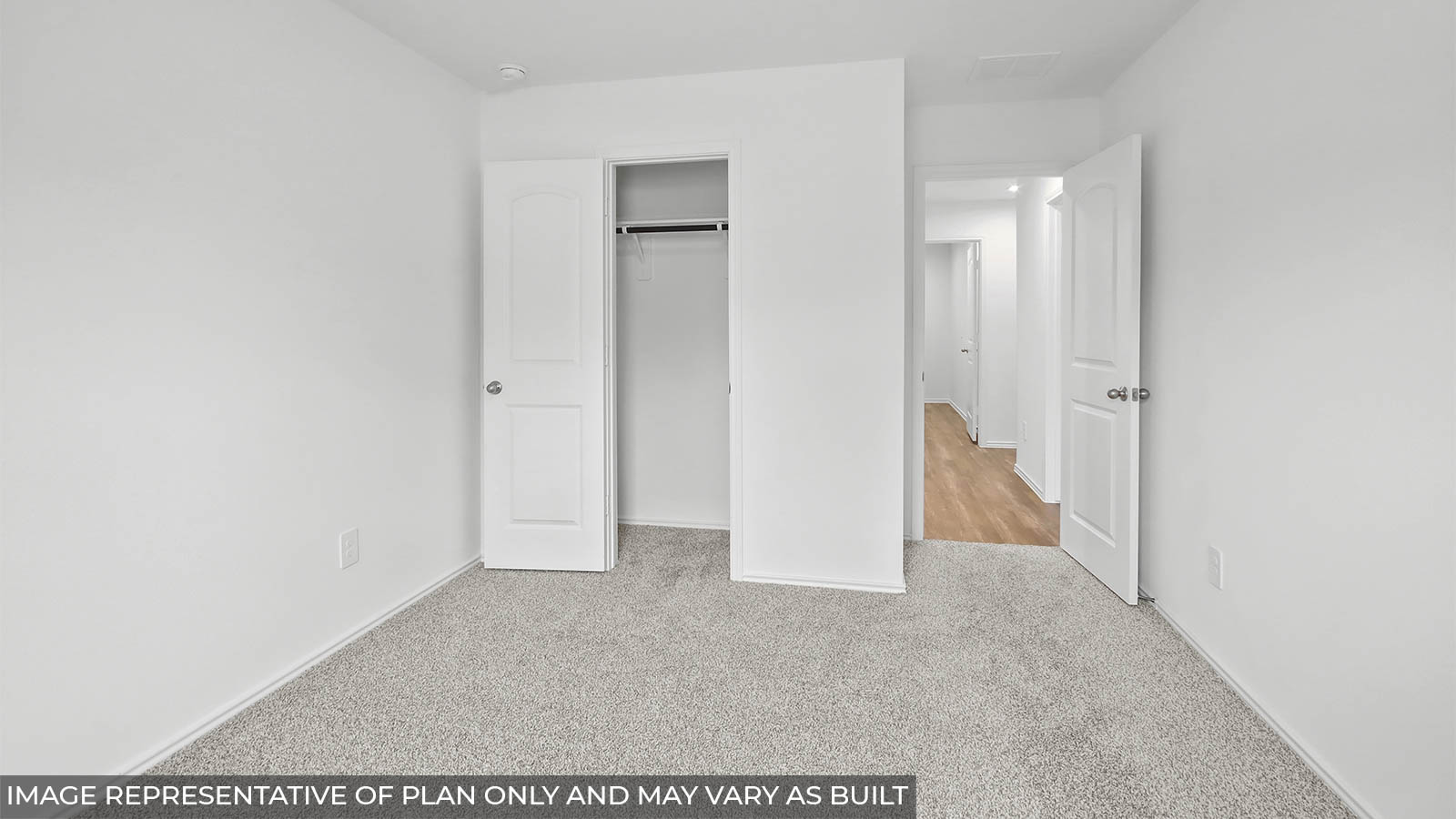 Secondary bedroom with a tall closet and carpet flooring.
