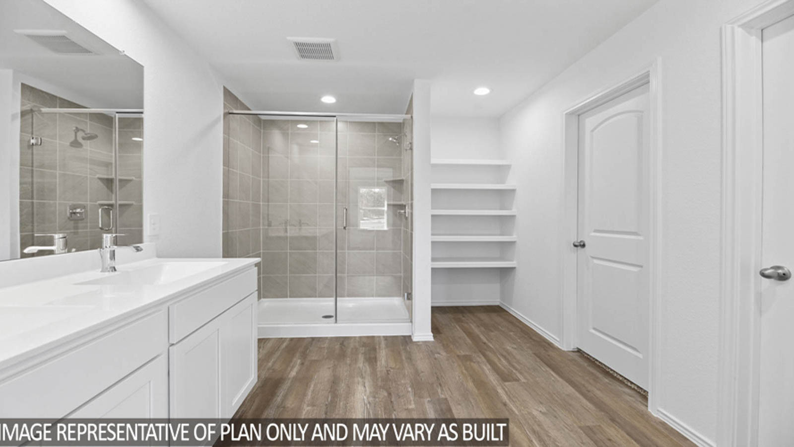 Primary bathroom with a double sink, a standing shower with a glass door, a linen nook, a separate toilet room, and a spacious walk-in closet.