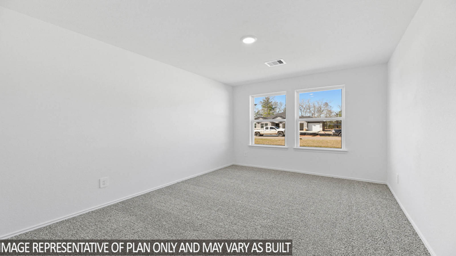 Secondary bedroom with carpet flooring, a tall closet, and bright windows.
