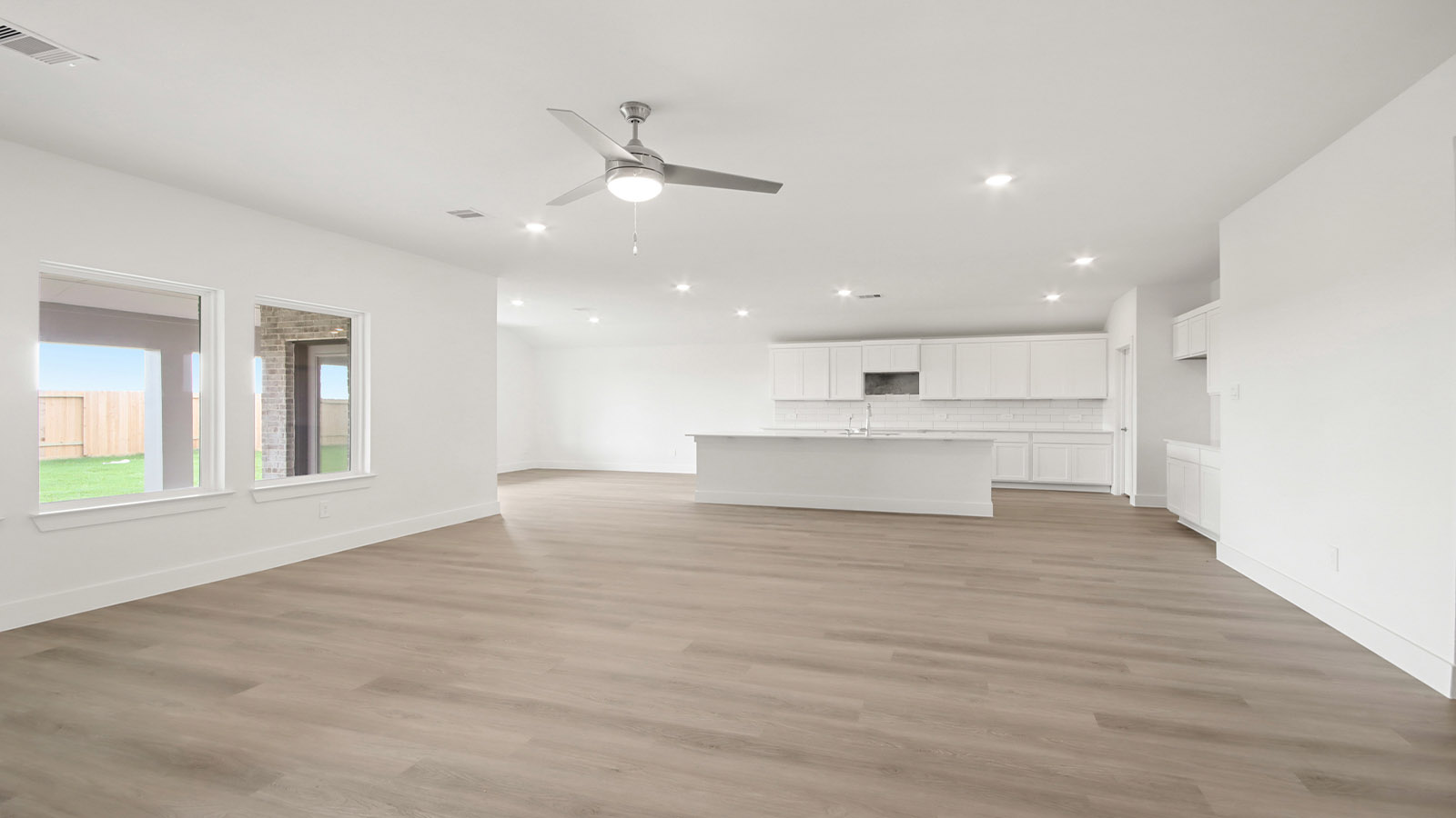 Spacious living area with vinyl flooring