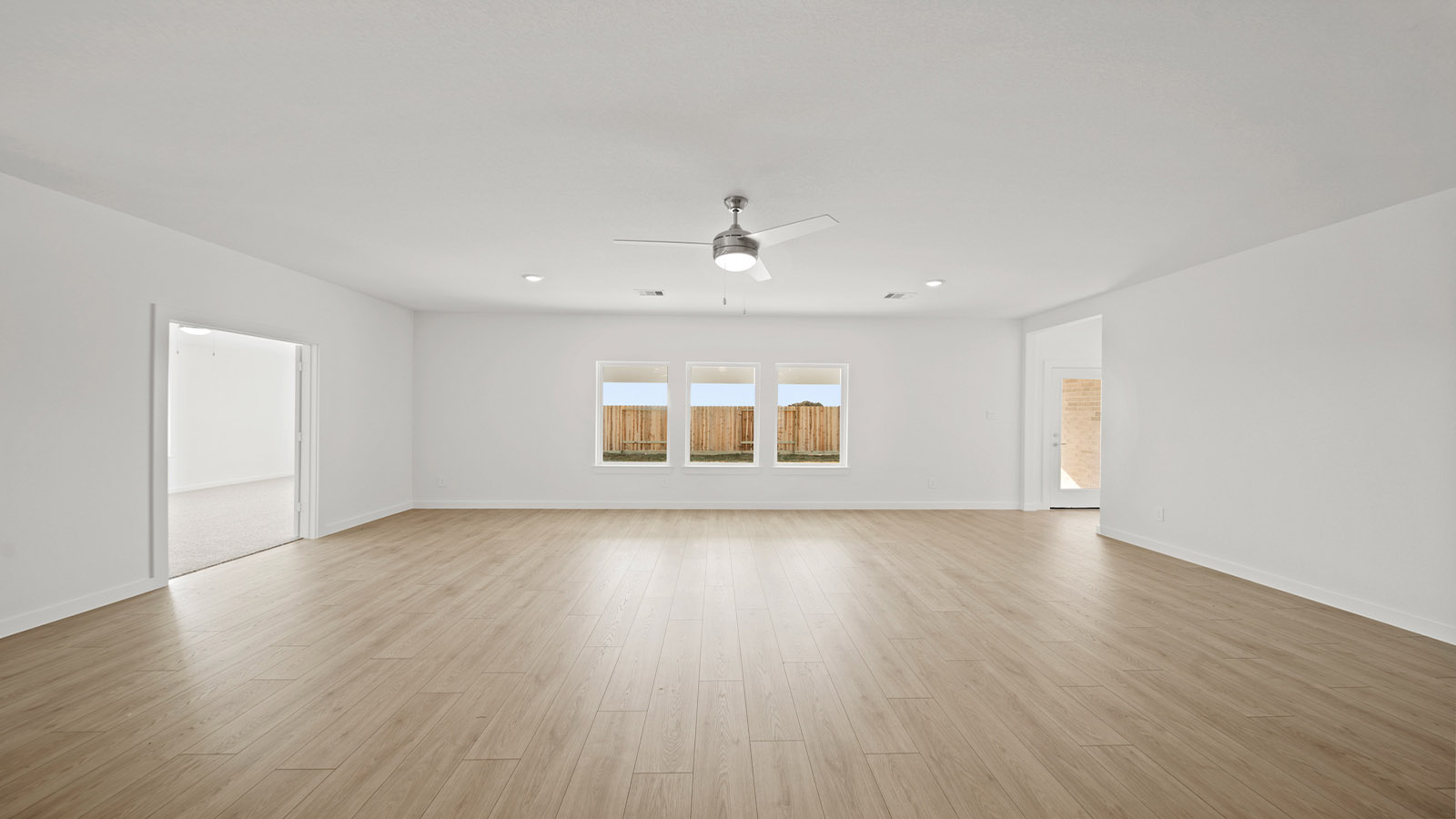 Spacious living area with vinyl flooring