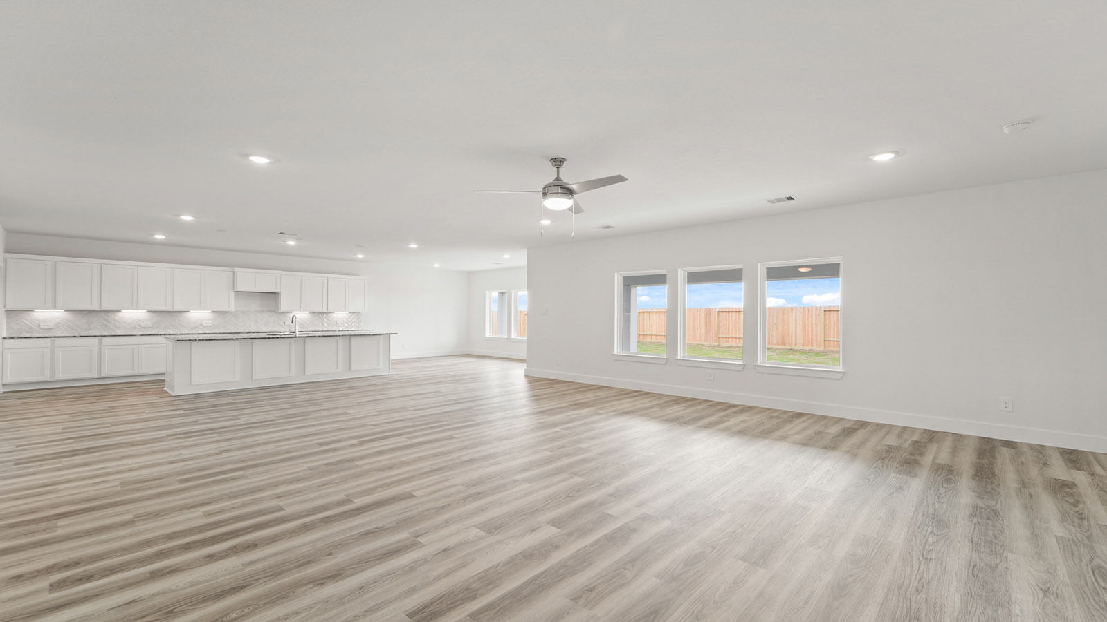 Spacious living area with vinyl flooring