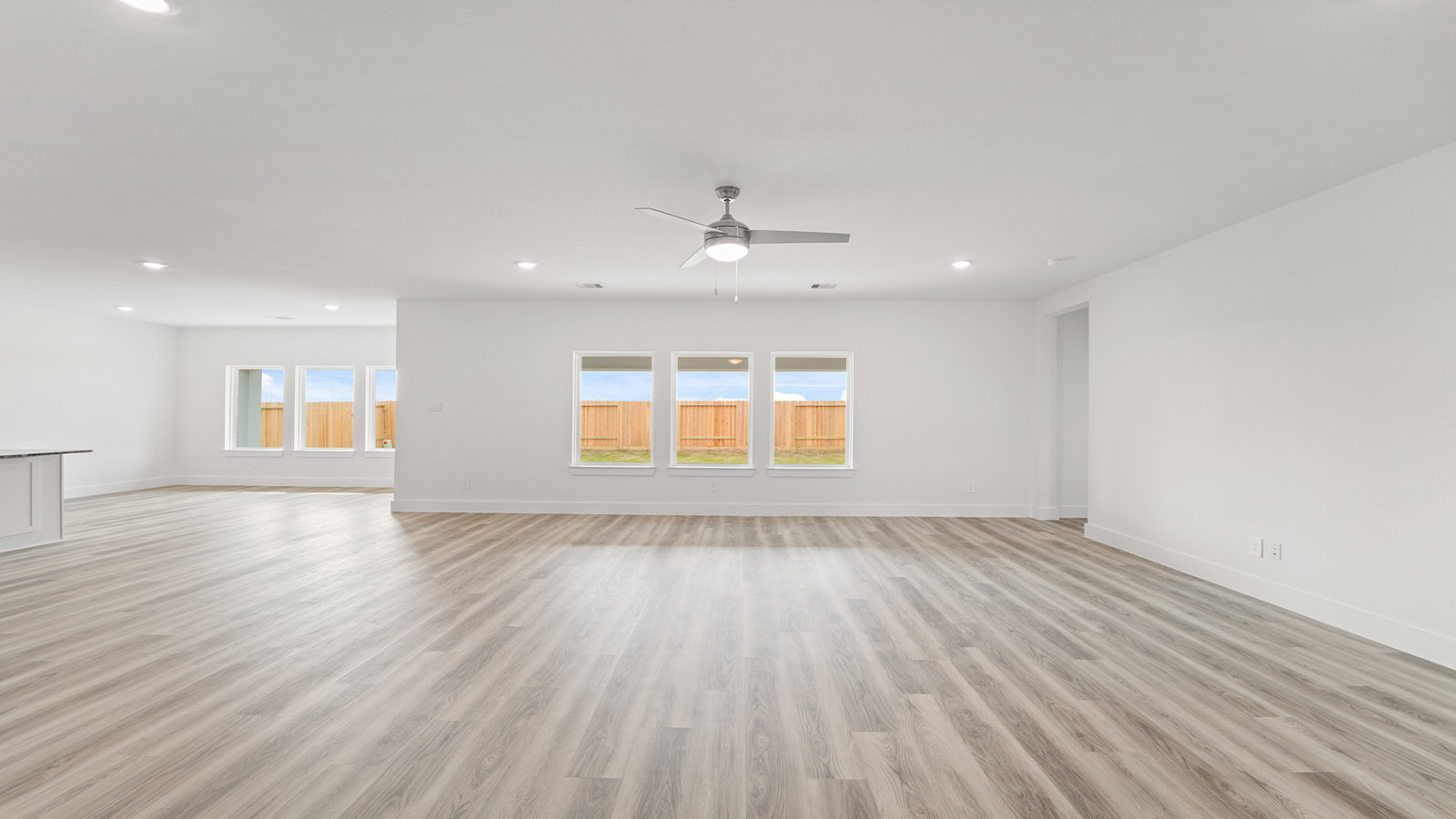 Spacious living area with vinyl flooring