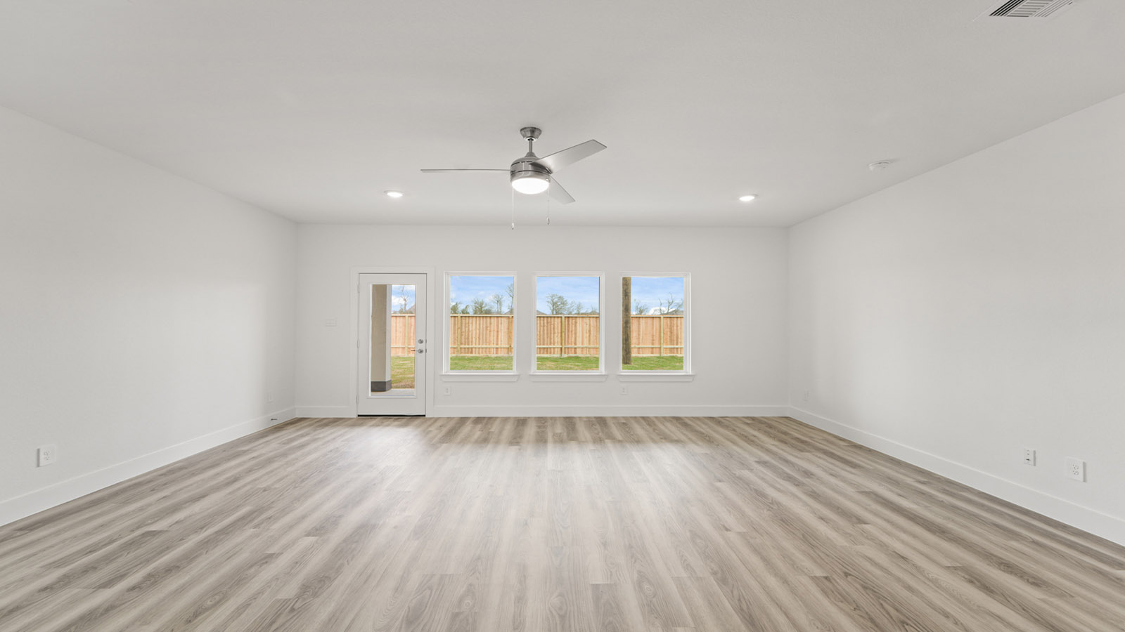 Spacious living area with vinyl flooring