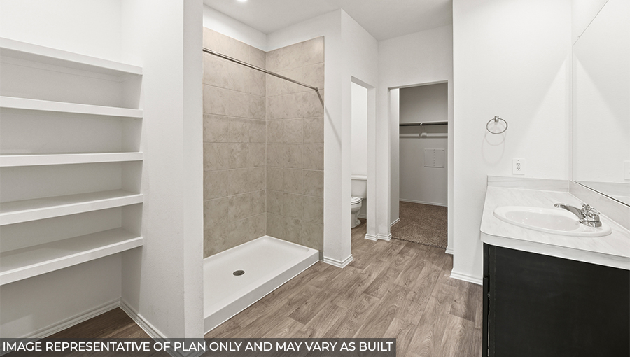 Primary bathroom with a linen nook, a standing shower, a separate toilet room, a double sink, and a spacious walk-in closet.