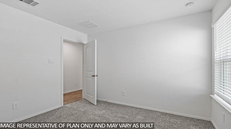 Secondary bedroom with carpet flooring