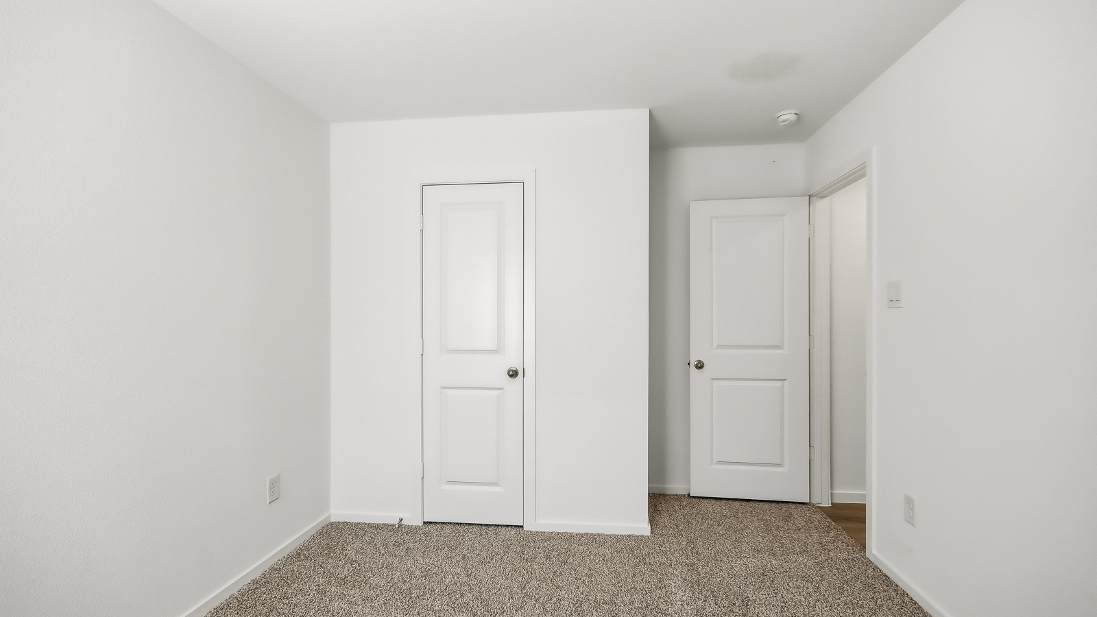 Secondary bedroom with carpet flooring