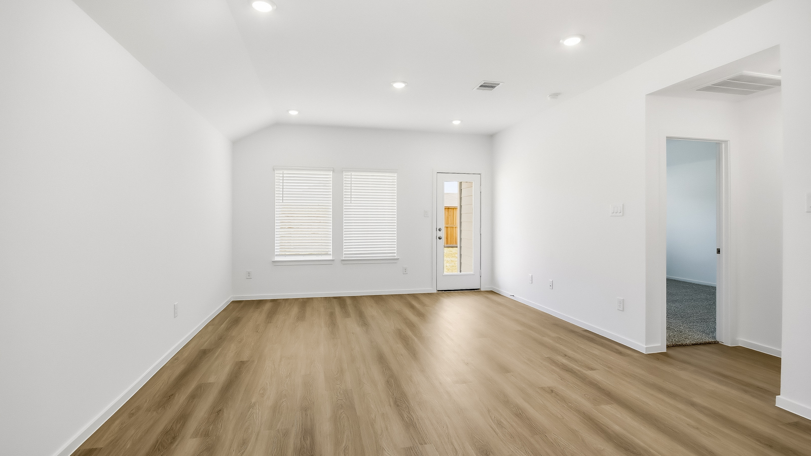 Spacious living area with vinyl flooring