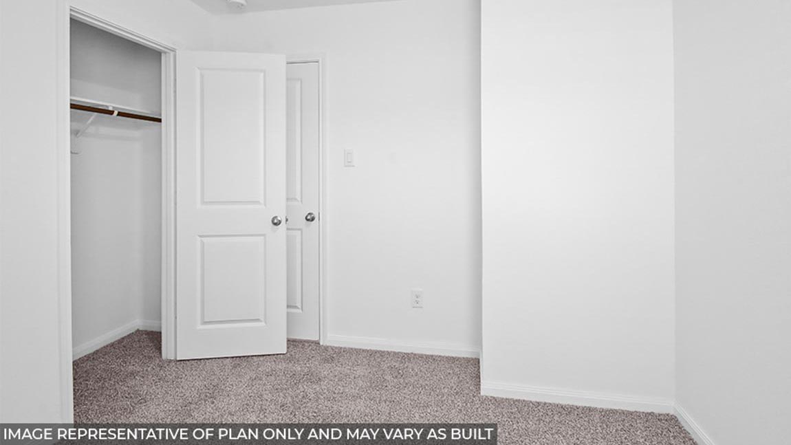Secondary bedroom with carpet flooring.