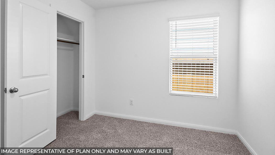 Secondary bedroom with carpet flooring and a bright window.