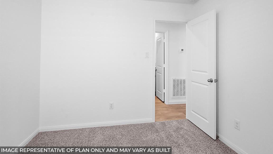 Secondary bedroom with carpet flooring.