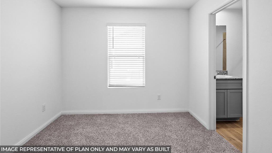 Primary bedroom with carpet flooring and a bright window.