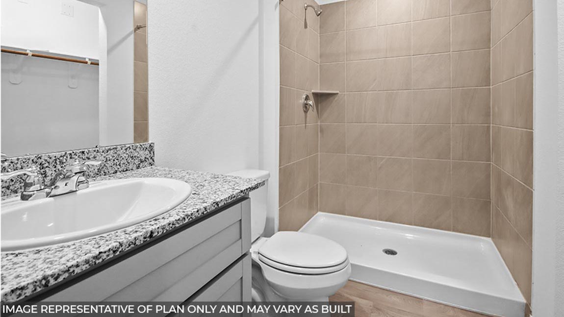 Primary bathroom standing shower and granite countertop sink.