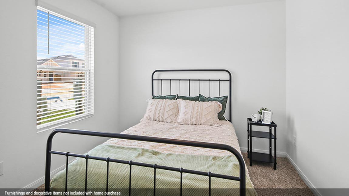 Primary bedroom with vinyl flooring and a bright window.