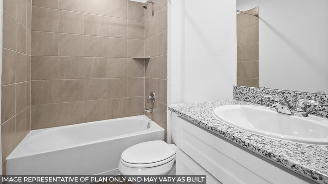 bathroom with tub and bath surround tile