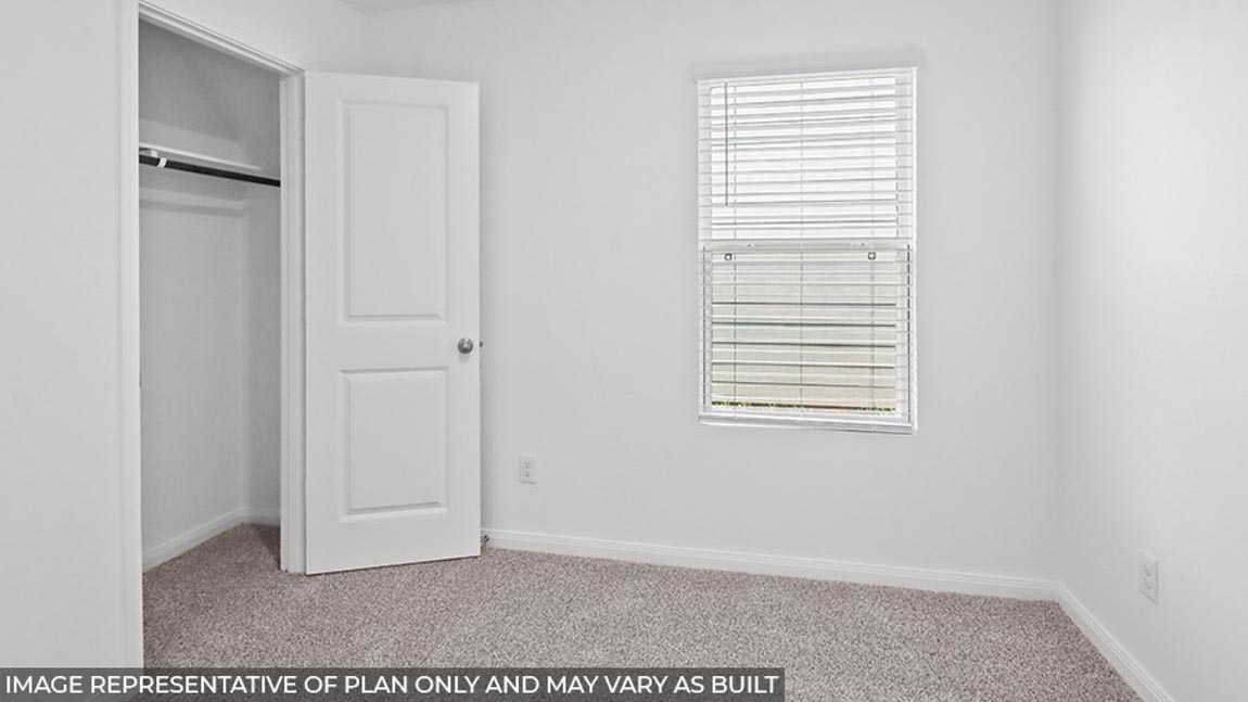 Secondary bedroom with carpet flooring and a bright window.