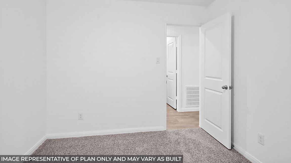 Secondary bedroom with carpet flooring.