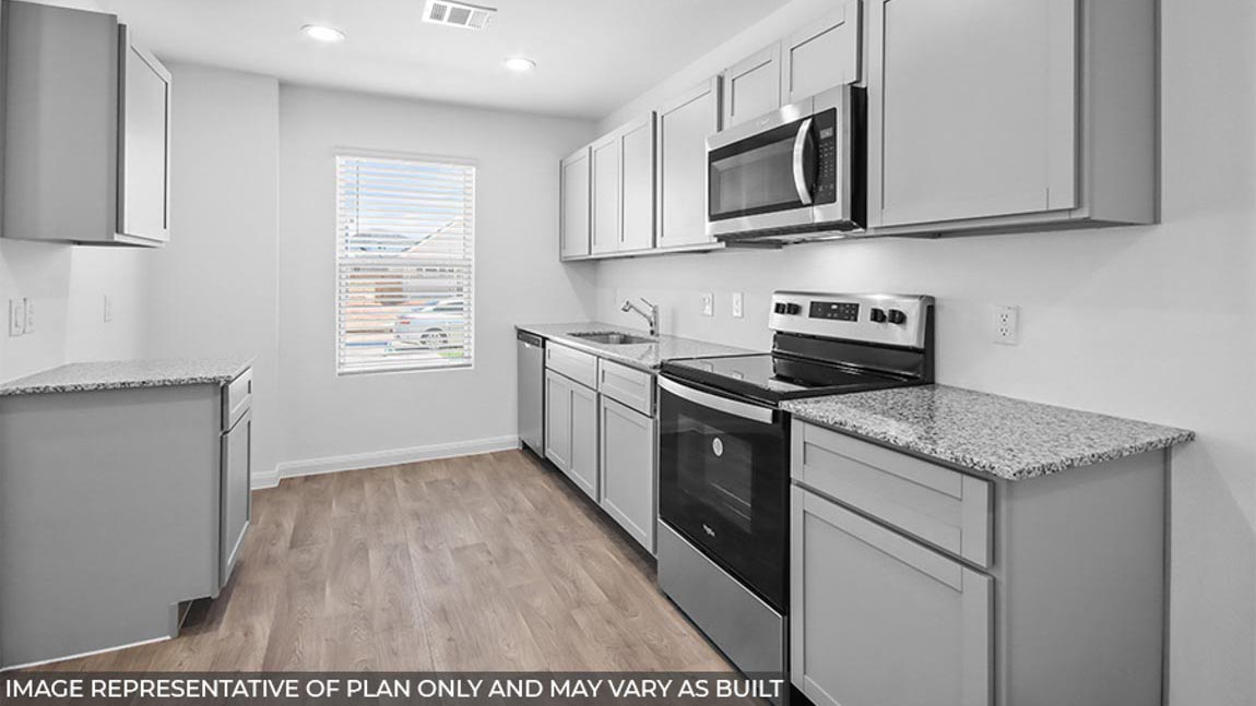 Kitchen with vinyl flooring and stainless-steel appliances.