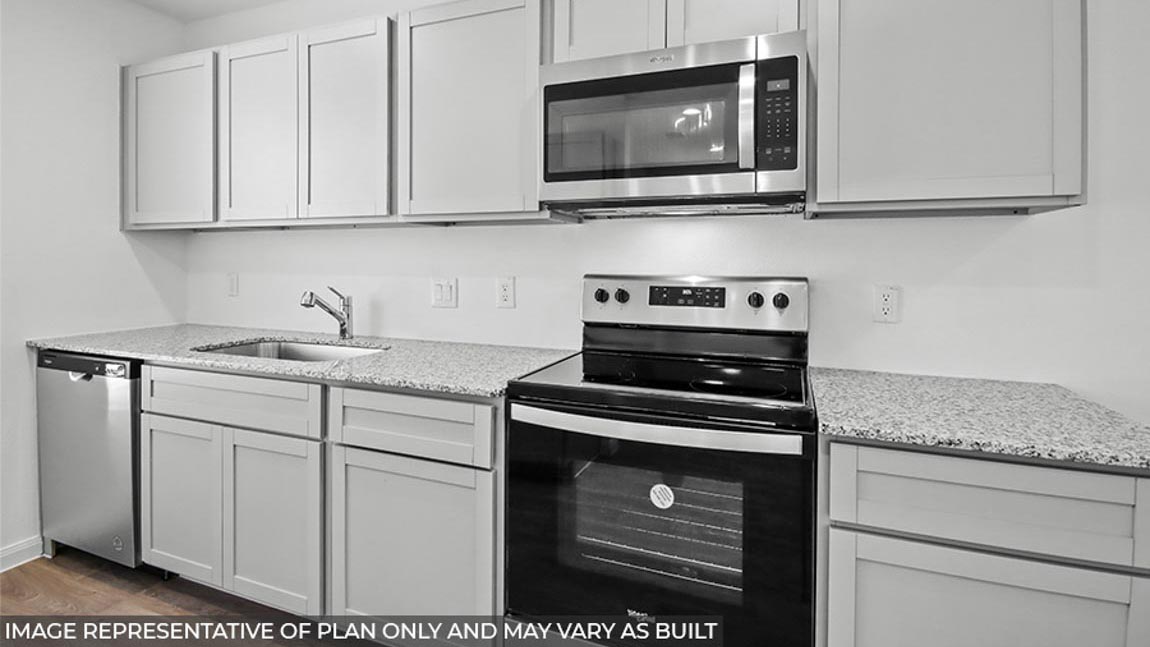 Kitchen with vinyl flooring and stainless-steel appliances.