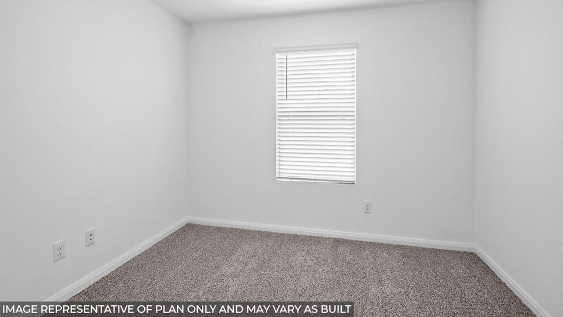 Secondary bedroom with carpet flooring and a bright window.