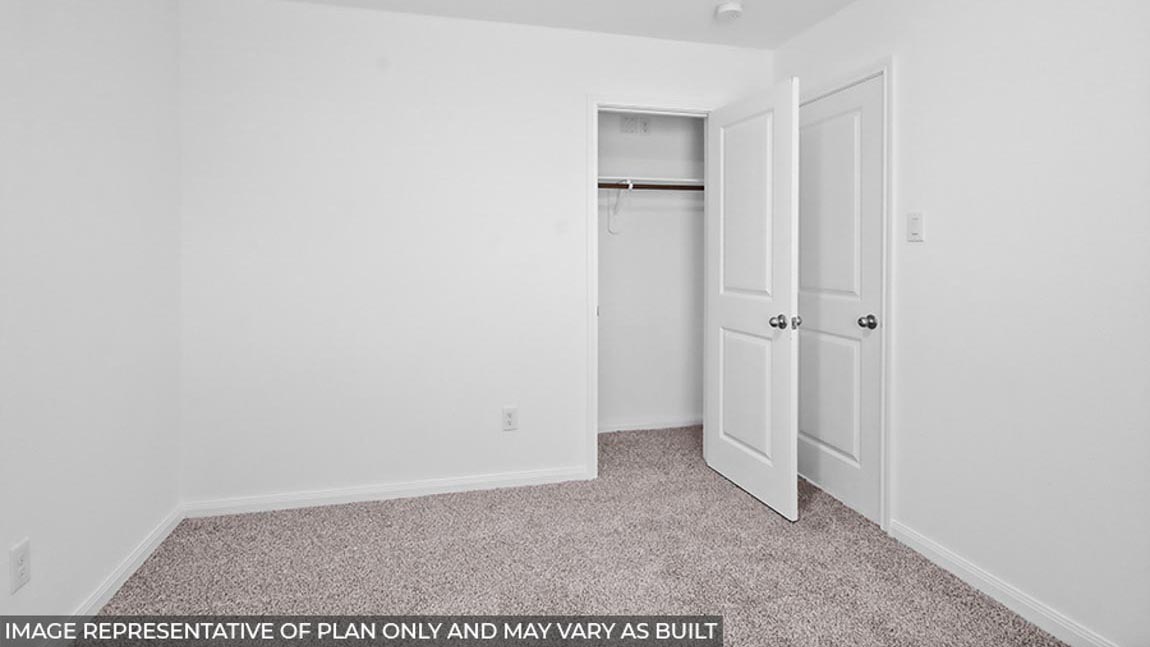 Secondary bedroom with carpet flooring.