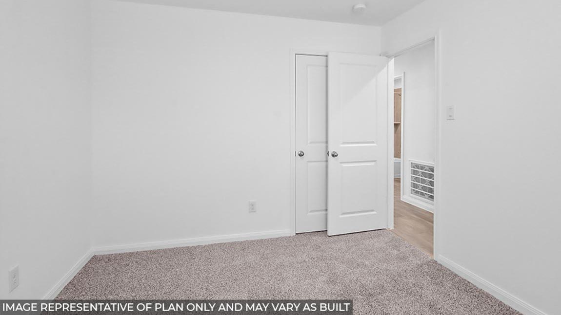 Secondary bedroom with carpet flooring.
